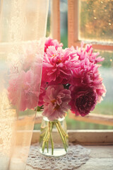 Still-life. A photo of pink peonies on the window.