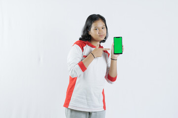 Young Asian woman looks happy in Indonesian Independence Day attire. woman shows her mobile phone with green screen suitable for advertising