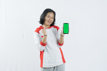 Young Asian woman looks happy in Indonesian Independence Day attire. woman shows her mobile phone with green screen suitable for advertising