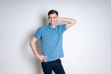 A man in a blue polo shirt is smiling and posing for a picture