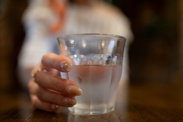 水の入ったグラスを持つ女性の手元
