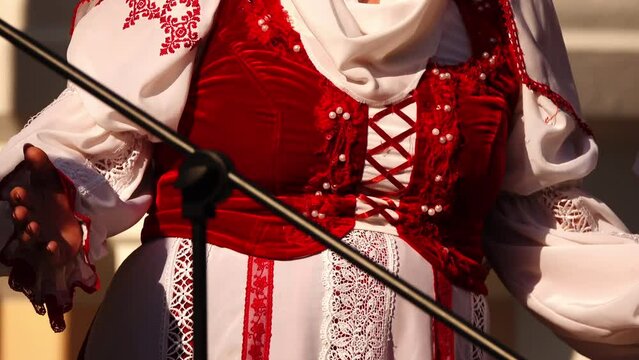 Women in national costumes dance at city folklore festival.