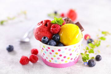 paper bowl with scoop of ice cream and blueberries fruits