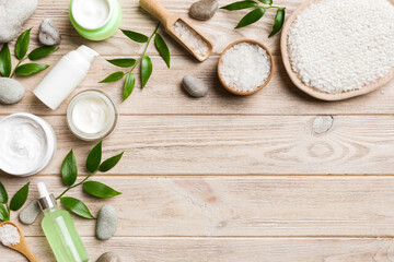 Coconut with jars of coconut oil and cosmetic cream on colored background. Top view. Free space for your text. Natural spa coconut cosmetics and organic treatment concept Coconut Spa composition