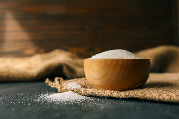 Sugar in a wooden bowl on burlap