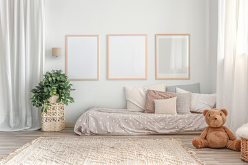 Kids room in pastel colors with toys, bed, scandinavian decor and 3 framed posters on the wall, scandinavian minimalistic design