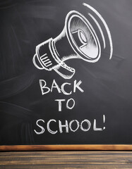 back to school text with a megaphone  on the chalkboard. Space for your text or design