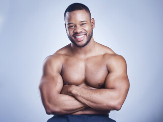Fototapeta premium Muscle, portrait and black man with arms crossed in studio for training, fitness or growth on gray background. Strong, wellness and shirtless bodybuilder for confidence, bicep or workout routine