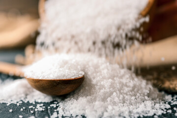 Pour salt into a wooden spoon, close-up