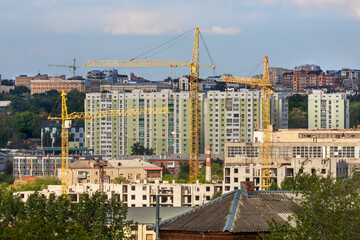 Cityscape of Kharkiv city in Ukraine. Construction cranes and multi-storey residential buildings. Urbanistic landscape