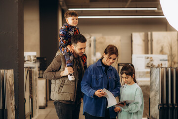 a young family chooses products in a catalogue in a hardware store
