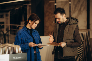 Middle age couple choosing ceramic tiles for their new bathroom
