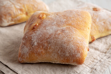 Homemade Cheese Ciabatta Buns on a white wooden background, side view. Close-up.