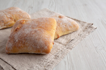 Homemade Cheese Ciabatta Buns on a white wooden background, side view. Close-up.