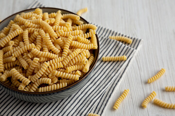 Raw Dry Organic Italian Fusilli Corti Bucati in a Bowl, side view.