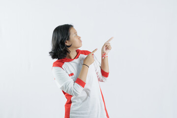 a young Indonesian woman raises her pointing finger with a big smile, the concept of Indonesia's independence day on August 17, isolated on a white background.