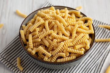 Raw Dry Organic Italian Fusilli Corti Bucati in a Bowl, side view.