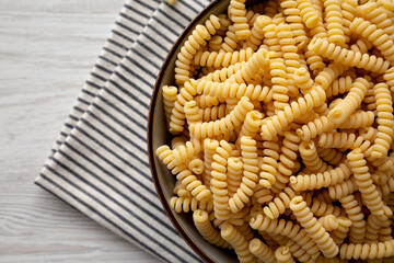 Raw Dry Organic Italian Fusilli Corti Bucati in a Bowl, top view. Close-up.