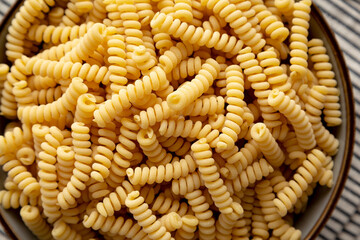 Raw Dry Organic Italian Fusilli Corti Bucati in a Bowl, top view. Close-up.