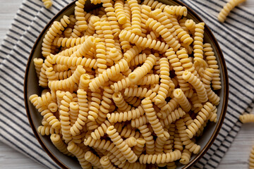 Raw Dry Organic Italian Fusilli Corti Bucati in a Bowl, top view. Close-up.