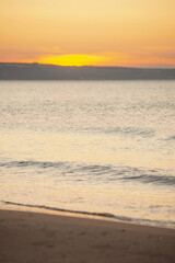 Tranquil sunset over calm ocean waves at serene beach, peaceful and mesmerizing scene with golden hues on the horizon