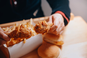 close up focus woman hand hold fried chicken for eat,girl with fast food concept