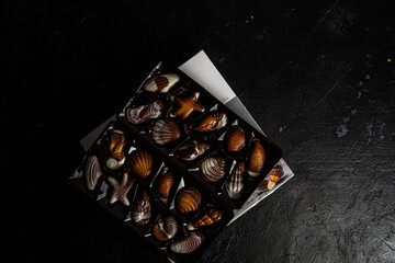 Chocolate candies in the shape of shells on a dark background