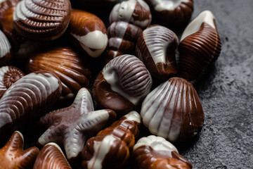 Chocolate candies in the shape of shells on a dark background