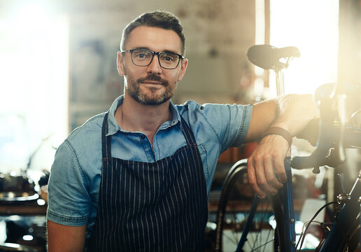 Portrait, happy and man with bicycle for mechanic career, business owner and working in maintenance garage. Mature male person, bike technician and professional skills for repair in service workshop