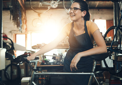 Woman, bicycle shop and thinking for maintenance work, startup with transport service. Bike, mechanic and female entrepreneur in workshop with idea, thoughtful for sustainable business with happiness