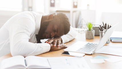 Exhausted african american young employee sleeping in his office, stress and tiredness concept, panorama with copy space