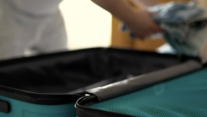 Man packing a suitcase for trip closeup. Travel concept slow motion.