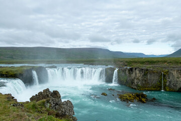 Icelandic landscape of the body of water, lakes and waterfall on a cloudy day from Akureyri