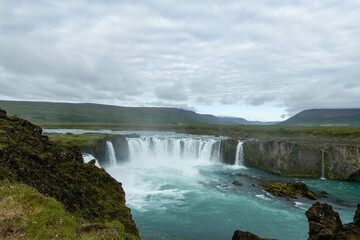 Icelandic landscape of the body of water, lakes and waterfall on a cloudy day from Akureyri