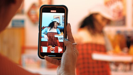 Happy customer record video of restaurant worker dancing and holding food tray at modern bar with food. Smart hispanic waitress preparing food order while customer hands holding camera. Regalement.