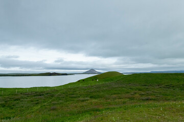 Icelandic landscape of the body of water, lakes and waterfall on a cloudy day from Akureyri