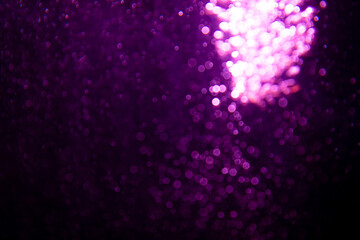 Abstract blurred purple glitter texture with sparkling bokeh lights creating a vibrant and festive background, ideal for holiday and celebration themes.