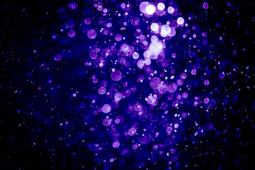 Blurred photo with purple violet and blue dots visible glittering, shining brightly look and feel luxurious