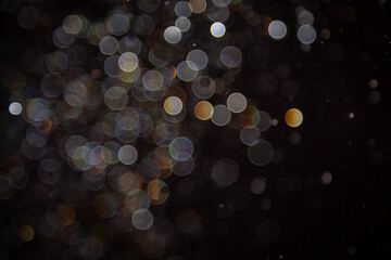 Abstract bokeh lights with colorful circles on dark background, creating a dreamy and festive...