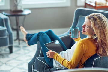 Happy, tablet and woman on couch, coffee and rest in living room, morning and social media in house. Relax, calm and girl with mobile, smile or peace in lounge, cozy and person with tea in apartment