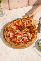 Sunlit Summer Meat Pizza with Bacon and Salami on Rustic Wooden Board