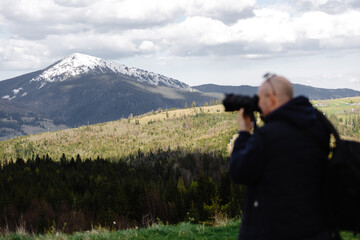 Photographer capturing mountain view in spring