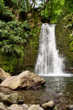 Waterfall Salto do Prego on the Isle of S&atilde;o Miguel, Azores, Portugal. Waterfall with tropical green vegetation and forests. Travel destination. Hiking on Azores Island.
