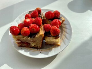 cottage cheese casserole with strawberries dipped in chocolate with fresh red berries on a porcelain plate on a white background
