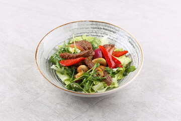 Beef steak salad with cherry tomatoes, cucumbers, red onions, romaine salad and lime mustard olive oil salad dressing