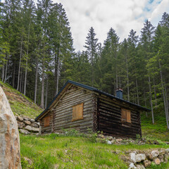 alpine houses on the edge of forest, wooden cabin next to the path, on the raodside, while hiking, we come across old alpine three stage farming huts, hiking in the mountains from Vorarlberg