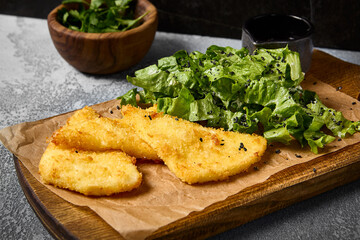 Crispy Fried Cheese with Mixed Greens and Berry Sauce on Wooden Board
