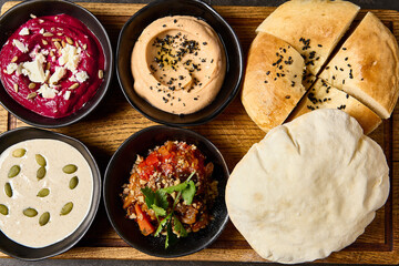 Assorted Mezze Platter with Pita and Flatbread Featuring Hummus, Beet Hummus, Adjapsandali, and Tonnato Sauce