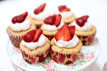 Homemade muffin with small pieces of strawberries, photographed in ambiental light.
