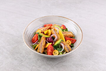 Crunchy thai style chicken salad in bowl over light stone background. Close up view
